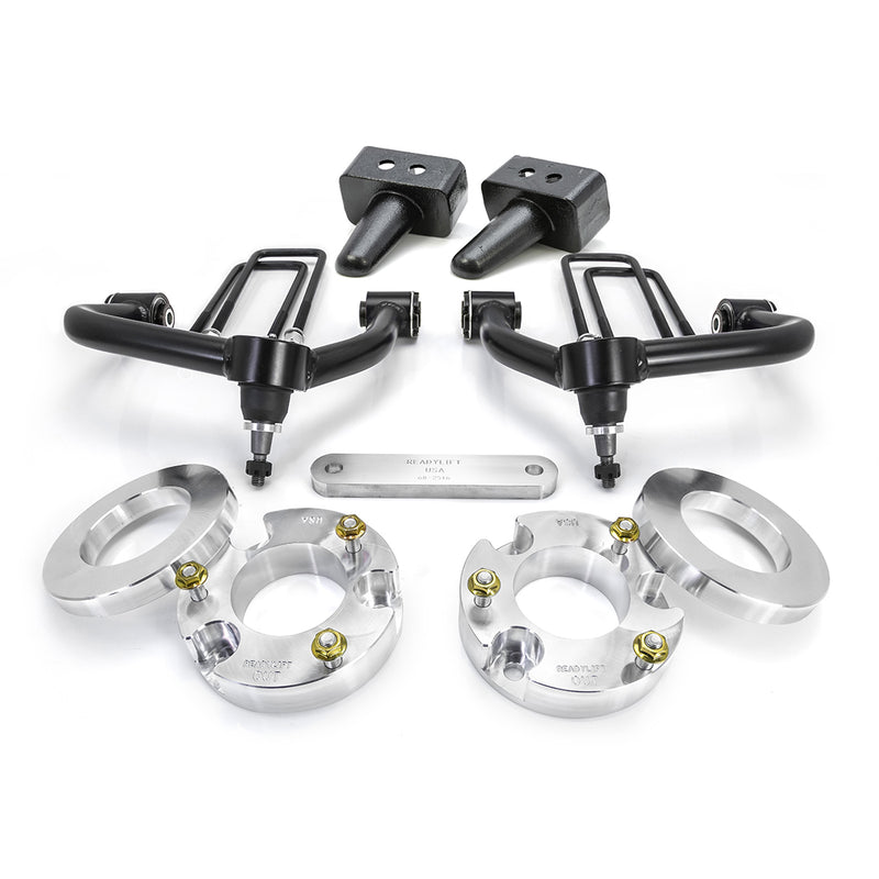 ReadyLIFT SST Lift Kit, full kit on a studio background: two black upper control arms, aluminum strut spacers, tapered rear blocks, U-bolts and a shim plate on white