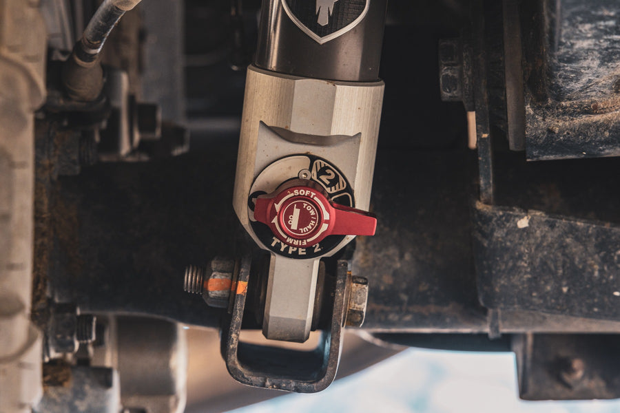 ReadyLIFT SST2.1 Coil Spring Lift Kit on a vehicle: close-up of an installed Falcon shock body with a red Type 2 adjuster knob under a truck