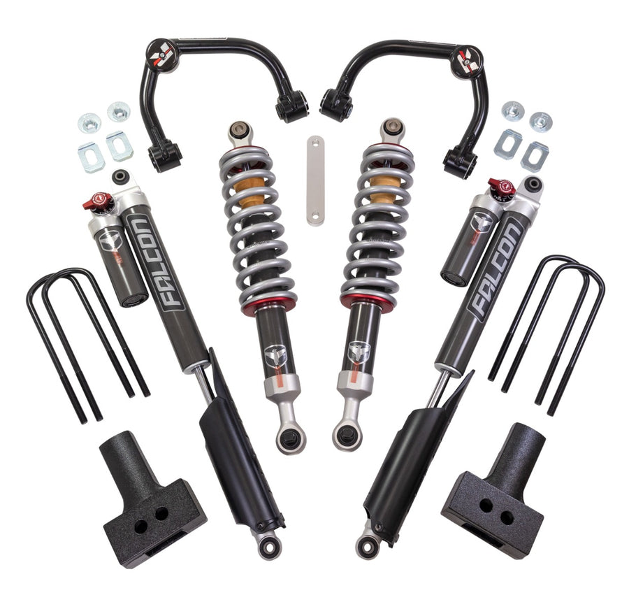 ReadyLIFT SST2.1 Suspension System, full kit on a studio background: two black upper control arms, two Falcon coilovers, two Falcon rear shocks with reservoirs, tapered blocks and U-bolts on white