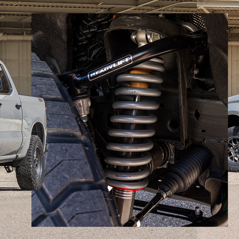 ReadyLIFT Suspension System on a vehicle: close-up of an installed Falcon coilover with a Hyperco spring and a black ReadyLIFT upper control arm in a wheel well