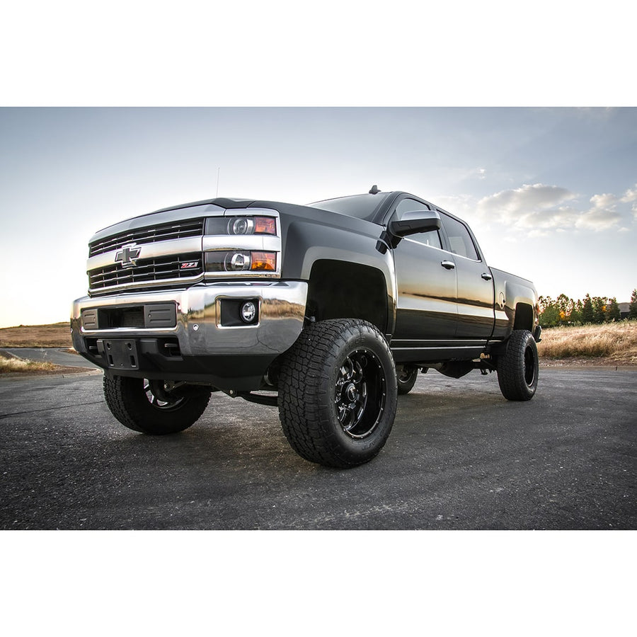 Big Lift Kits by ReadyLIFT: Black Chevrolet Silverado 1500 crew cab lifted on black wheels, low front angle on a paved lot at dusk.