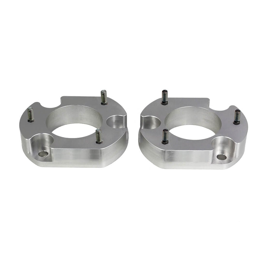 Leveling Kits by ReadyLIFT: Pair of machined aluminum strut spacers with studs on white.