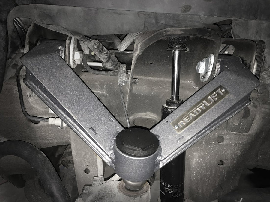 Leveling Kits by ReadyLIFT: Gray ReadyLIFT fabricated upper control arm installed in a GM front suspension seen from the wheel well.