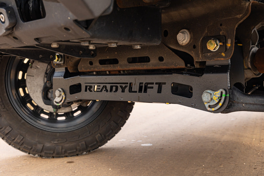 MAX Suspension Systems by ReadyLIFT: ReadyLIFT-stamped front crossmember installed under a truck behind the front tire.