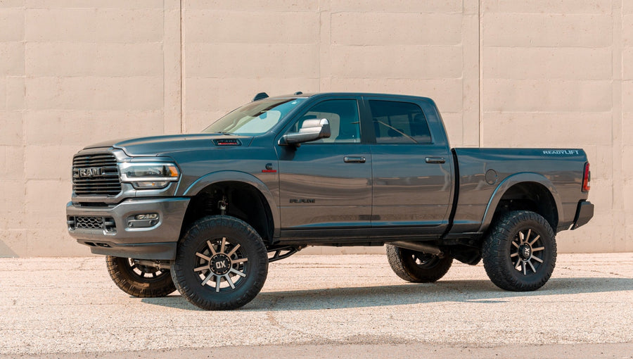 MAX Suspension Systems by ReadyLIFT: Blue-gray Ram 2500 crew cab lifted on bronze wheels in front of a concrete wall.