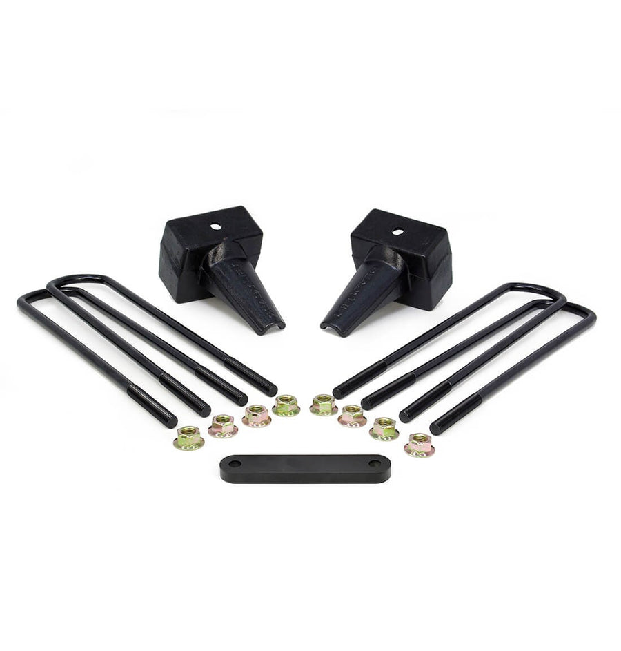 Rear Block Kits by ReadyLIFT: Two black tapered rear lift blocks with square black U-bolts, gold nuts and a flat spacer plate on white.
