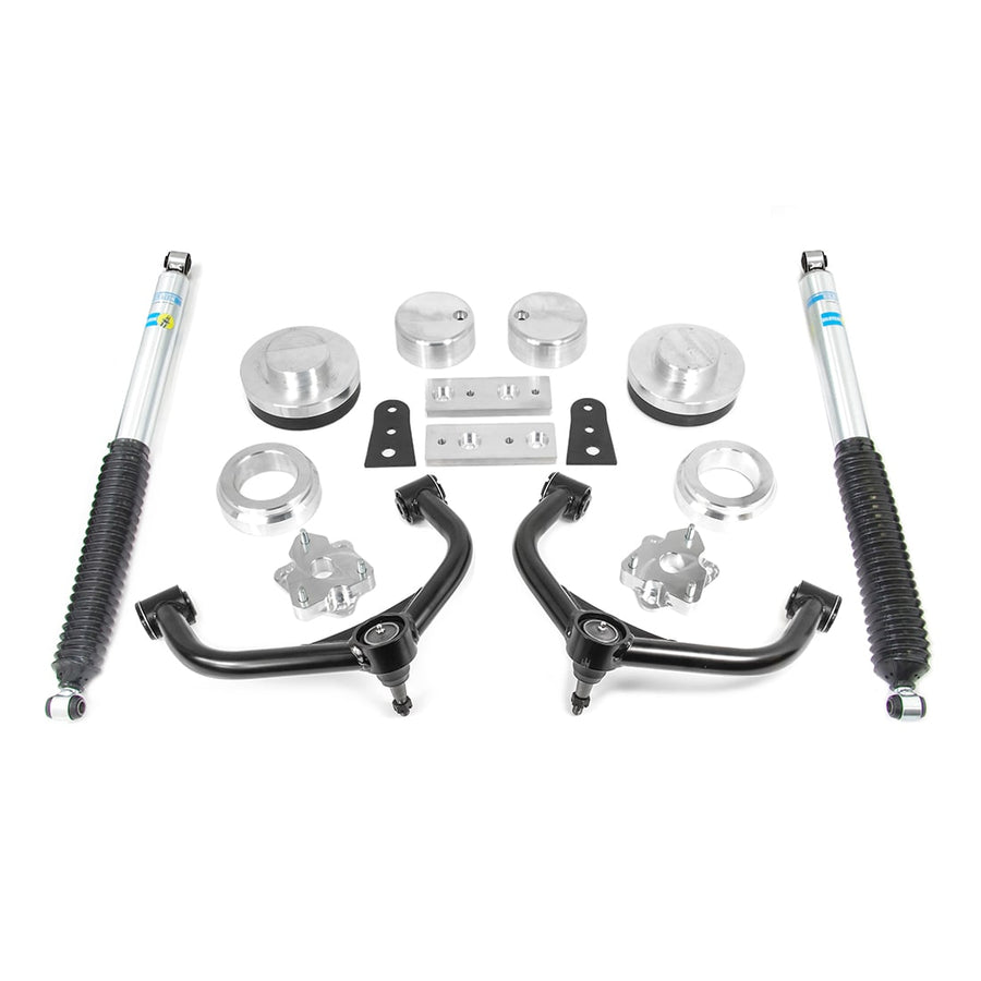 SST Lift Kits by ReadyLIFT: Aluminum spacers, black upper control arms, brackets and two blue-and-yellow Bilstein rear shocks on white.