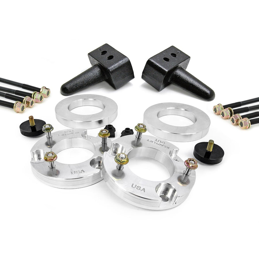 SST Lift Kits by ReadyLIFT: Aluminum strut spacers, two tapered rear blocks, U-bolts and bump stops on white.