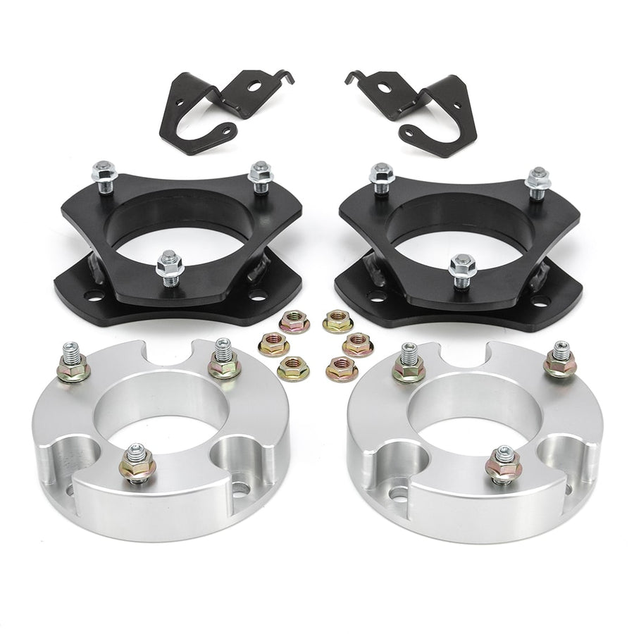 SST Lift Kits by ReadyLIFT: Two black strut spacers, two aluminum spacers, two brackets and nuts on white.