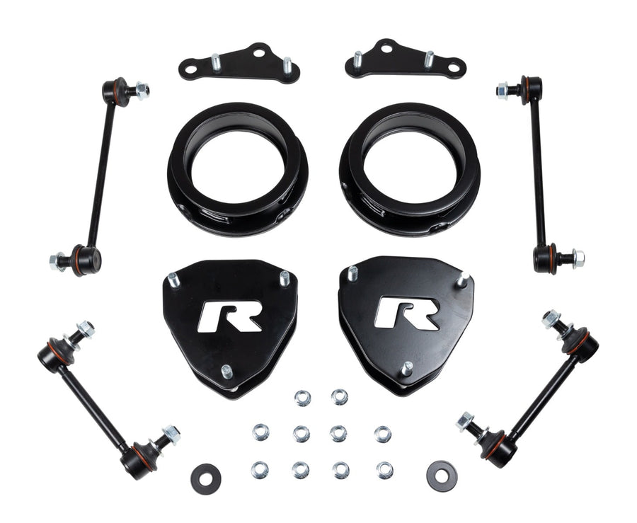 SST Lift Kits by ReadyLIFT: Two black round strut spacers, two black ReadyLIFT R top plates, brackets, four sway bar links and washers on white.