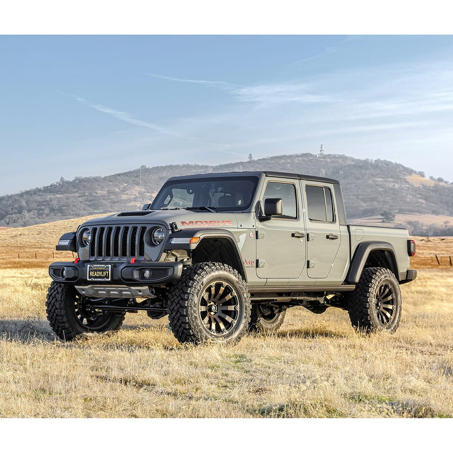 SST Lift Kits by ReadyLIFT: A gray lifted Jeep Gladiator Mojave with a ReadyLIFT front plate parked in a dry grass field.