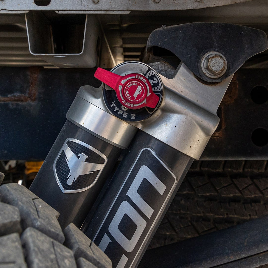 SST Performance Lift Kits by ReadyLIFT: Close-up of an installed Falcon piggyback shock with a red Type 2 adjuster knob beside a tire.