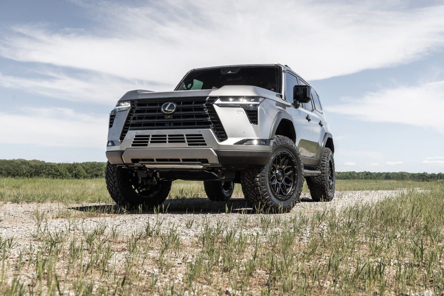 SST Performance Lift Kits by ReadyLIFT: A silver lifted Lexus GX550 parked on a gravel track in a grass field.