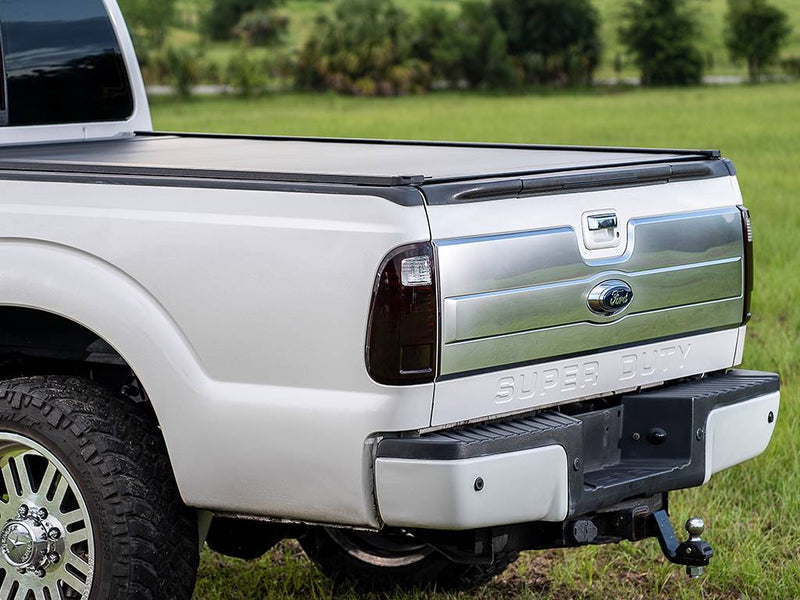 Close rear-quarter view of a white pickup on grass with the PowertraxONE XR closed