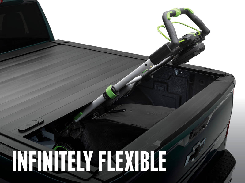 PRO MX held part-open with a leaf blower and gear wedged between cover and tailgate, INFINITELY FLEXIBLE caption