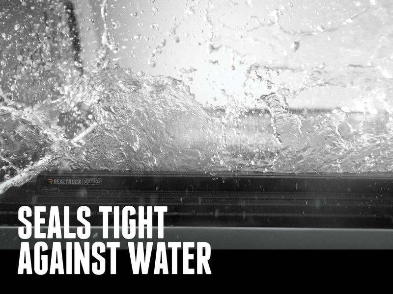 Water splashing over the closed cover edge with the Retrax badge, SEALS TIGHT AGAINST WATER caption