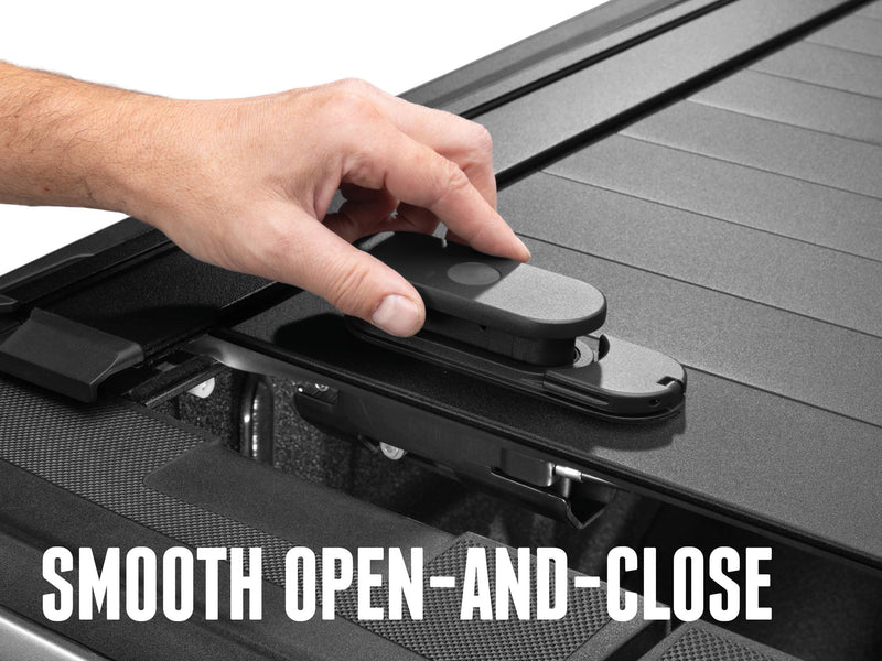Hand pressing the TraxLatch handle on the slatted cover, overlay Smooth Open-and-Close