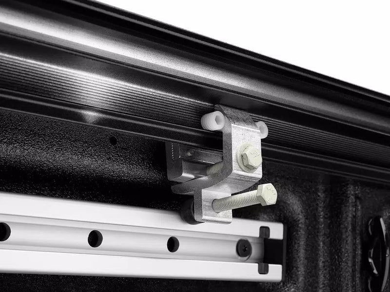 Under-rail clamp bolting the cover rail to the bed rail