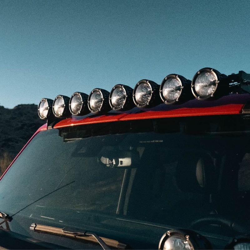 Rigid 360 Connect 40" Light Bar Assembly installed on a vehicle: an eight-pod 360 Connect bar mounted along the front edge of a red roof above a windshield at dusk