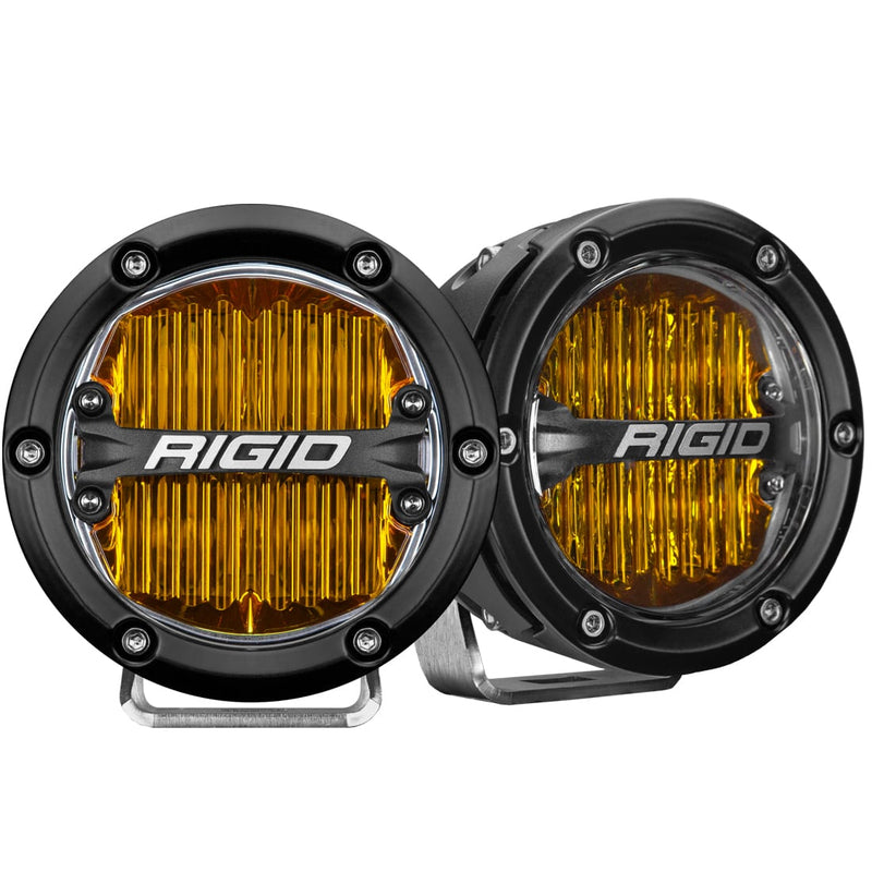 Rigid 360-Series PRO 4" SAE Pair on a studio background: A pair of black 4" round SAE fog lights with yellow lenses on polished brackets against white