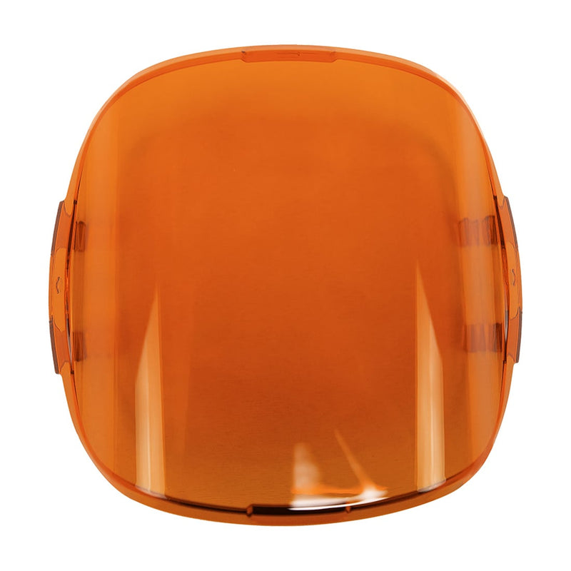 Rigid Adapt XP Cover on a studio background: translucent amber snap-on lens cover with a rounded square shape on white