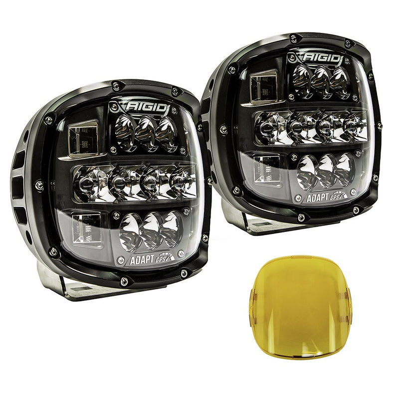 Rigid Adapt XP Pair, kit contents laid out: A pair of black Adapt XP LED lights with clear lenses angled on white, with a yellow snap-on cover beside them