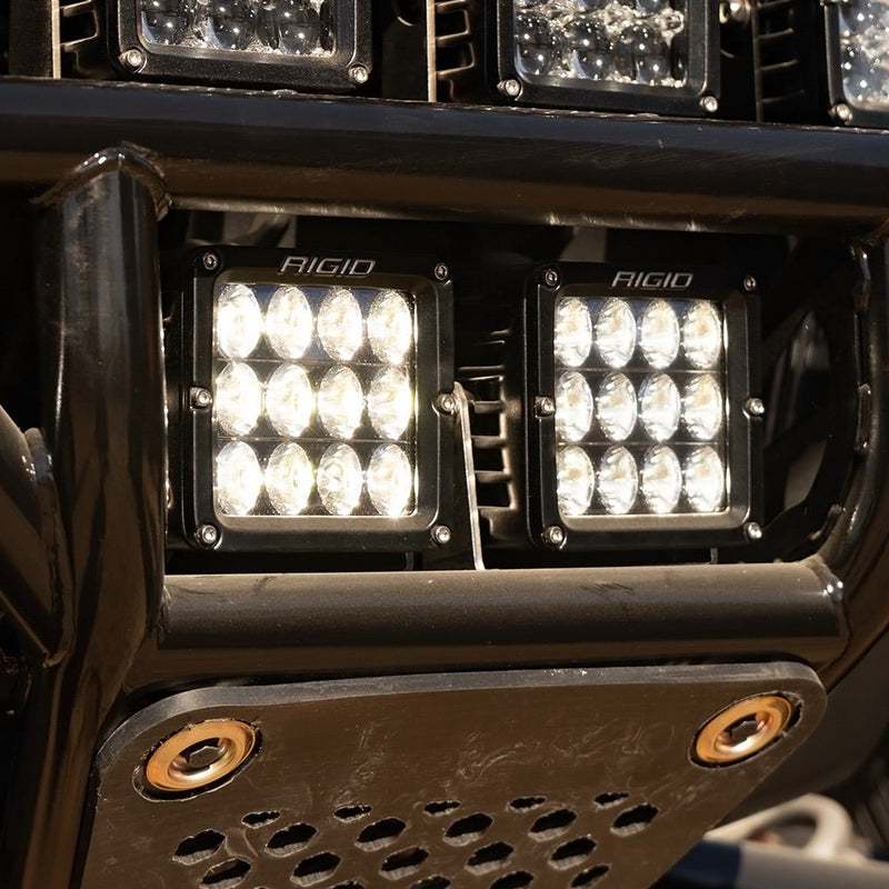 Rigid D-XL PRO Pods Pair installed on a vehicle: two D-XL pods with nine-LED optics glow white side by side in a black off-road bumper