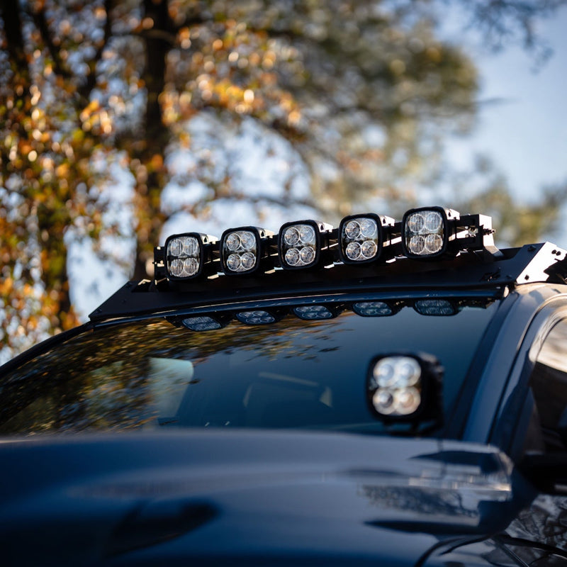 Rigid Phoenix 40" Connect Bar installed on a vehicle: five-pod light bar mounted on the roof rack of a dark blue vehicle, with an A-pillar pod below