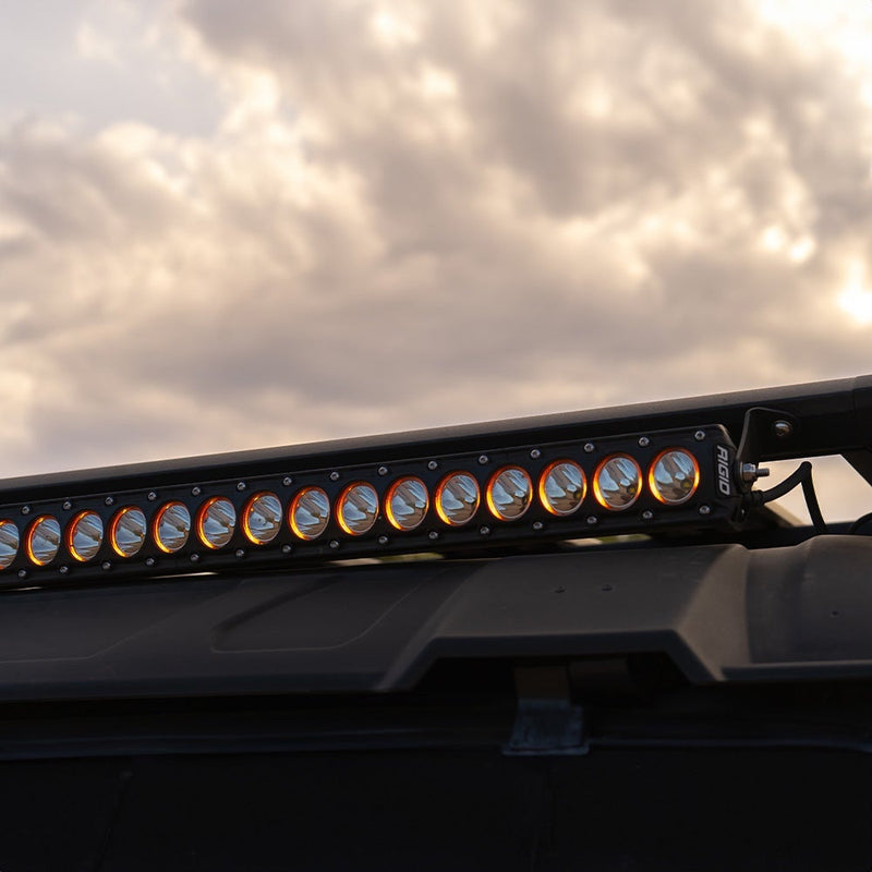 Close-up of the Rigid Revolve 40" Bar: A close-up of a Revolve light bar with amber-ringed reflectors mounted on a roof rack against a cloudy sky