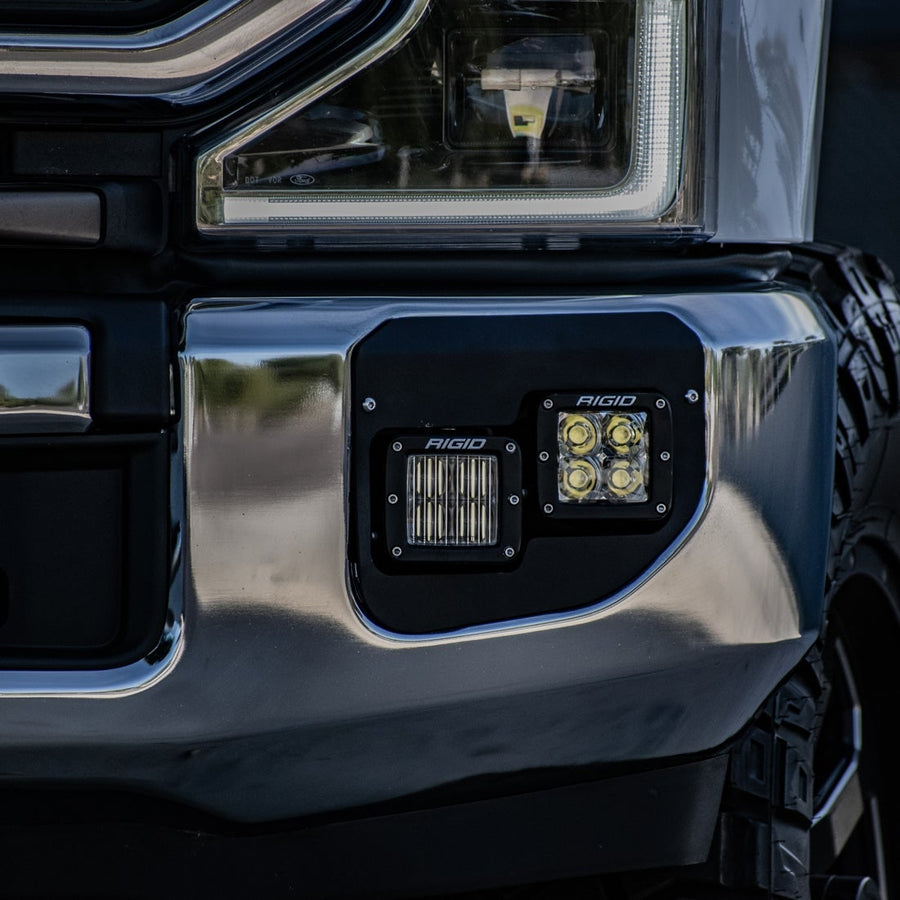 Vehicle-Specific Light Kits by Rigid: Two Rigid D-Series pods fitted in the fog pocket of a chrome front bumper.