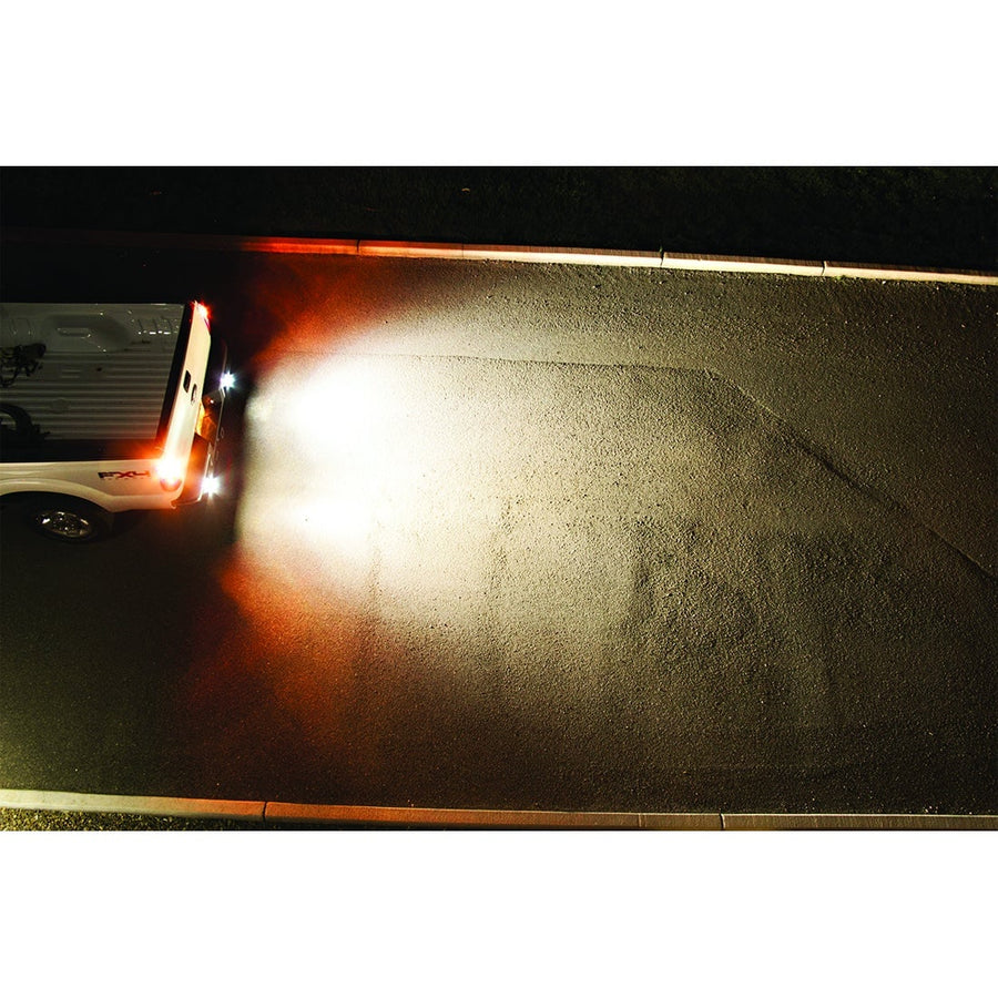 Light Mounts & Hardware by Rigid: Backup lights flood a wide patch of ground behind a vehicle at night.