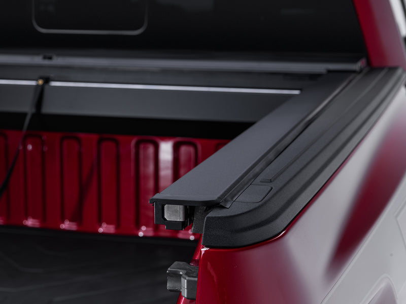 Roll-N-Lock A-Series rail end cap and square-drive clamp head at the tailgate corner