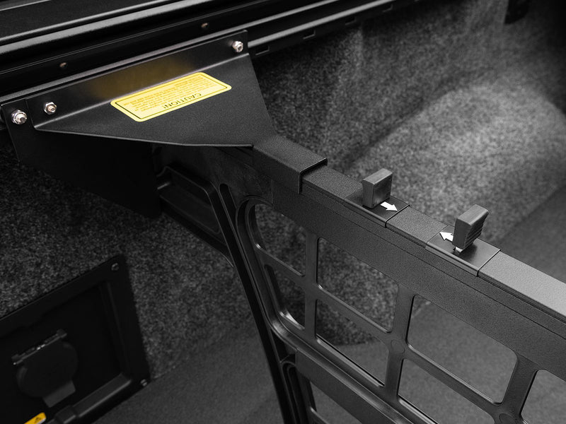 Roll-N-Lock Cargo Manager arm, slider and its directional arrows against a carpeted bed liner