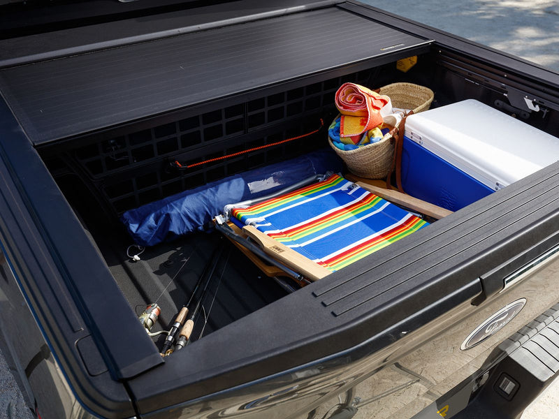 Looking into an open bed loaded with gear, Roll-N-Lock E-Series retracted