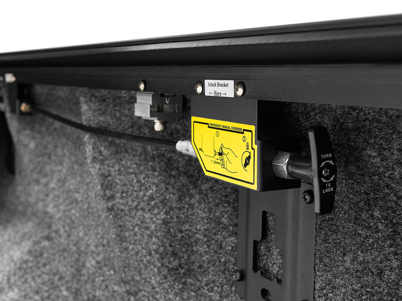 Roll-N-Lock E-Series powered lock lever and turn-lock bracket against a carpeted bed liner