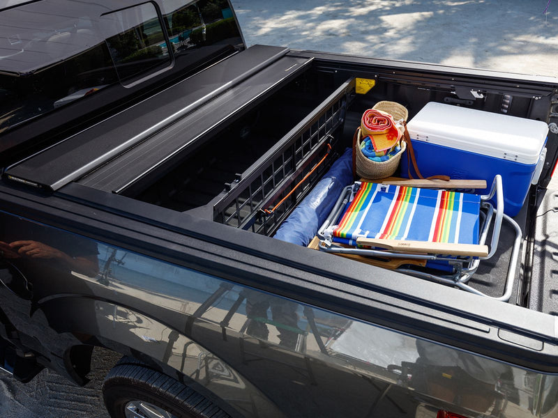 Roll-N-Lock E-Series stopped part open over a loaded bed, high three-quarter view