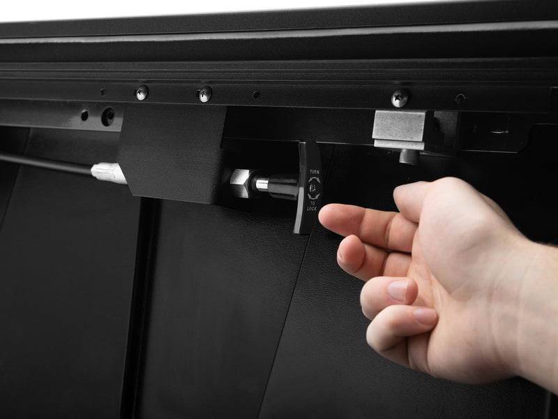 A hand releasing the Roll-N-Lock E-Series XT rail catch at the bulkhead