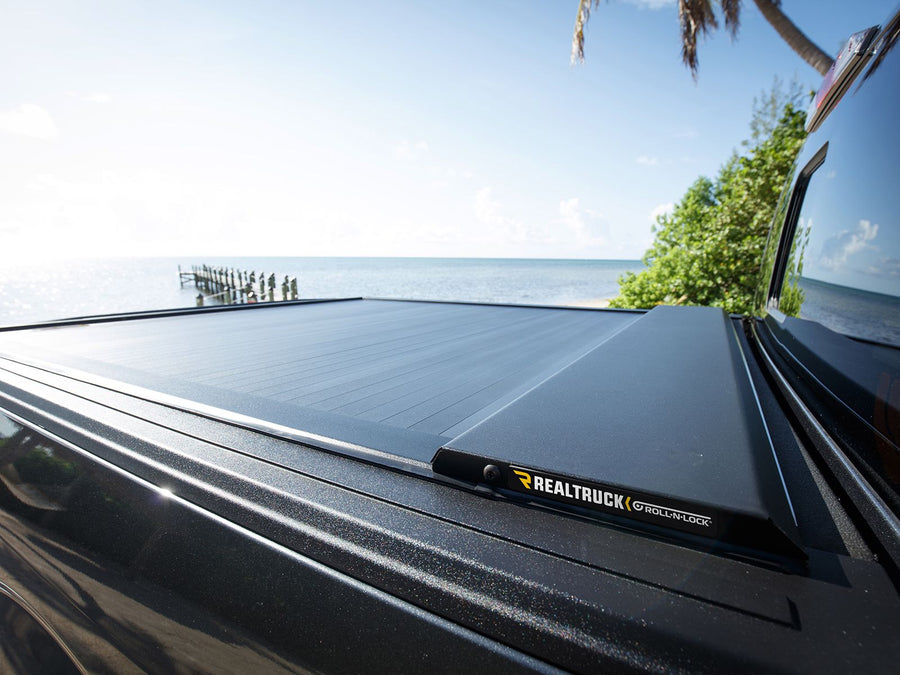 Roll-N-Lock E-Series cover closed along the bed rail by the ocean
