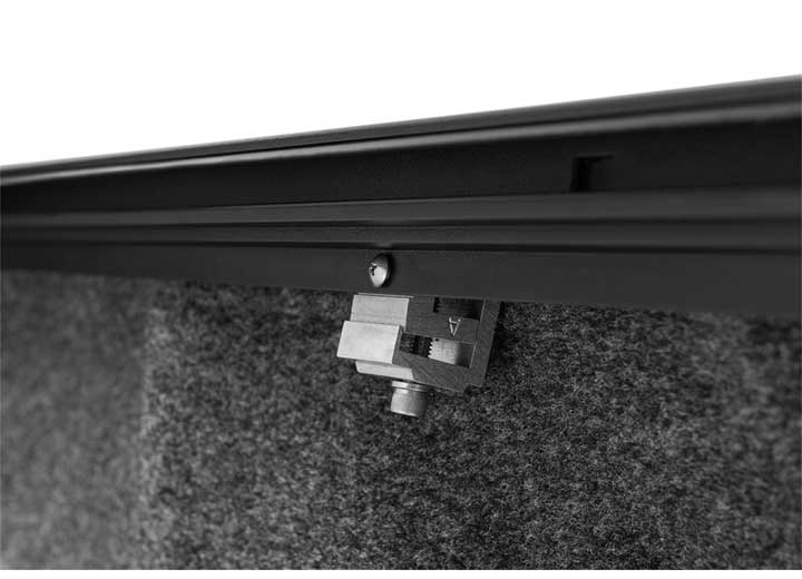 Roll-N-Lock M-Series rail clamp gripping the underside of the bed rail