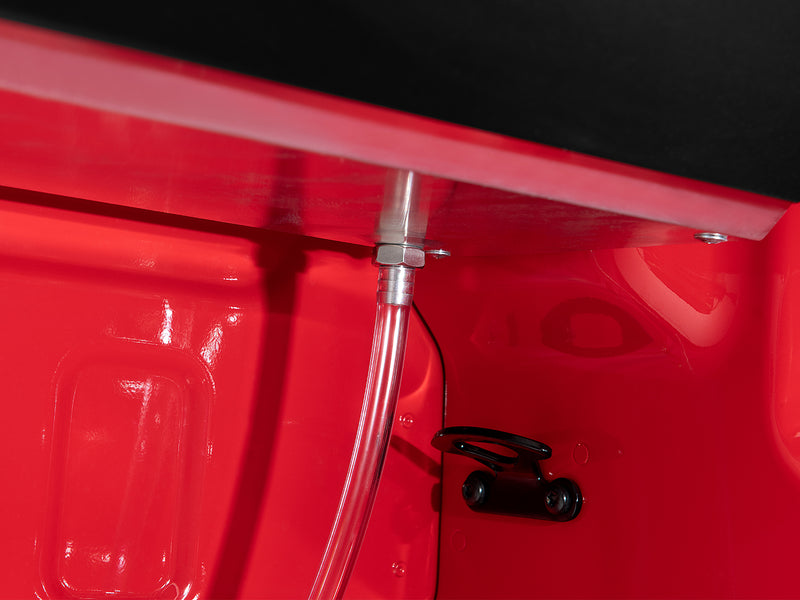 Roll-N-Lock M-Series XT drain tube running down the bed wall from the rail