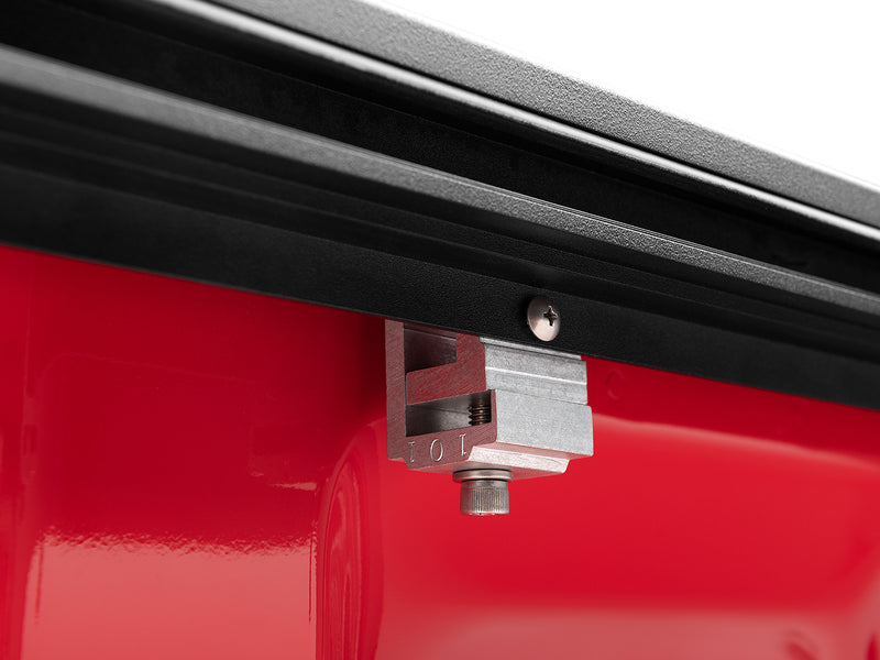 Roll-N-Lock M-Series XT cast aluminum rail clamp gripping the bed lip from underneath