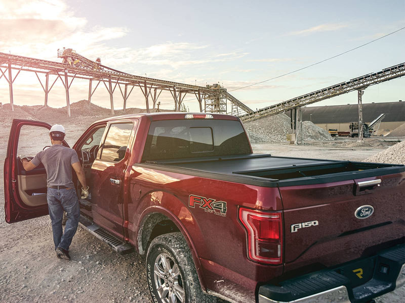 Roll-N-Lock A-Series closed cover on a pickup at a gravel plant, worker at the open cab door