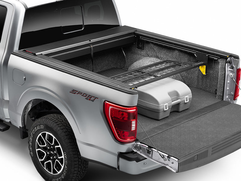 Roll-N-Lock Cargo Manager bed divider holding a storage case forward, rear three-quarter (tonneau cover sold separately)