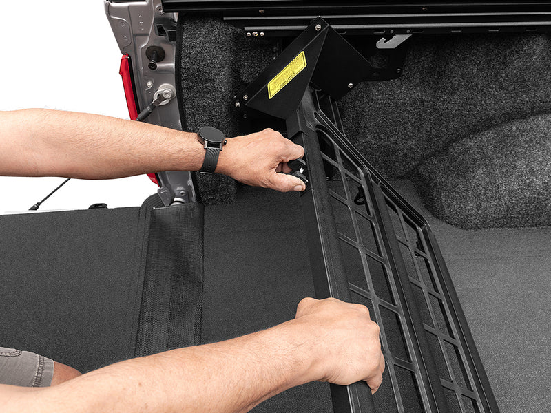 Roll-N-Lock Cargo Manager hands lifting the bed divider into position