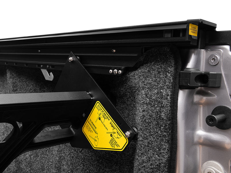 Roll-N-Lock Cargo Manager divider pivot bracket in the bed rail with its yellow operating label
