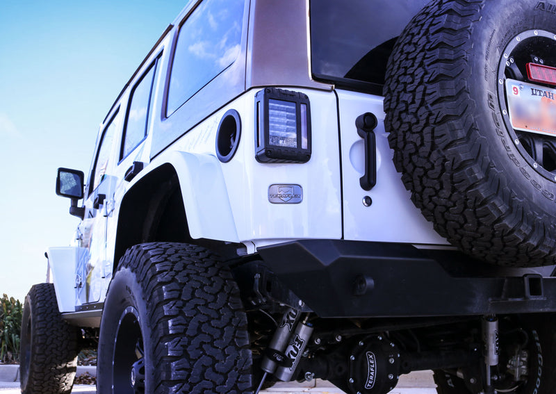 TeraFlex license plate delete badge installed on the tailgate of a white Jeep Wrangler JK