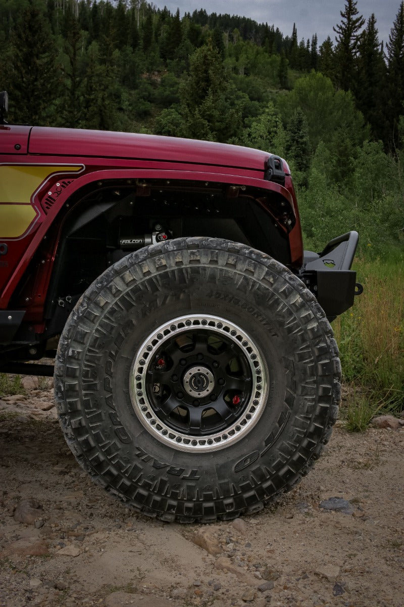 TeraFlex Off-Road Wheel on a Jeep Wrangler: front wheel of a red TeraFlex Jeep with black/machined beadlock wheel, Nitto Trail Grappler tire and Falcon shock