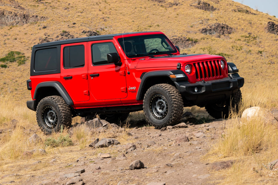 Red lifted JL Unlimited Sport on a dry hillside