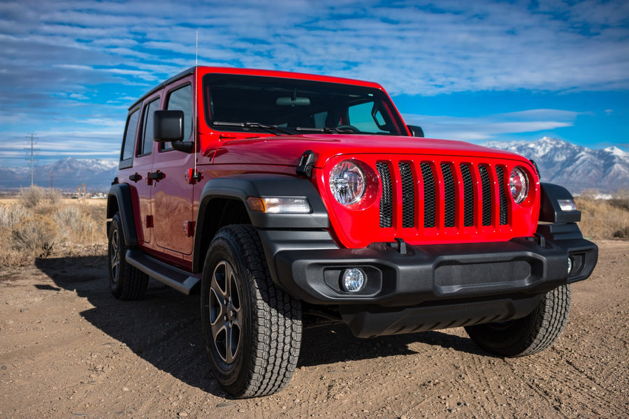 Red stock JL Unlimited Sport front close-up with snowy mountains