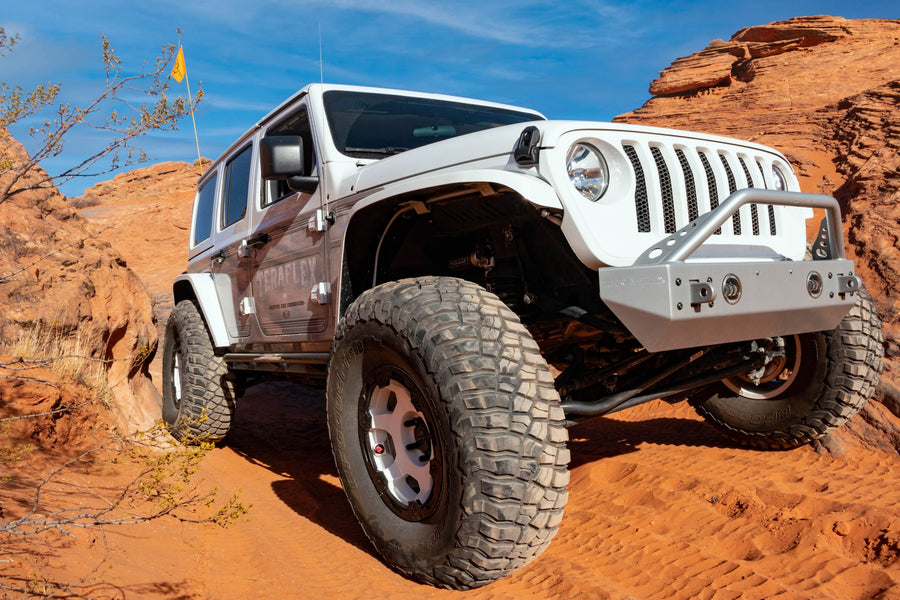 White lifted JL Unlimited with stubby front bumper in a sand canyon